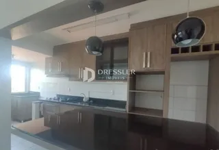 Cozinha com armários de madeira e bancada escura.