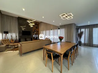 Ambiente de sala de estar e jantar com móveis de madeira.