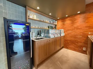 Vista de uma cozinha com armários de madeira e revestimento de tijolo aparente.