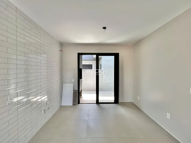 Hall de entrada com parede de tijolos brancos e piso de cerâmica clara.