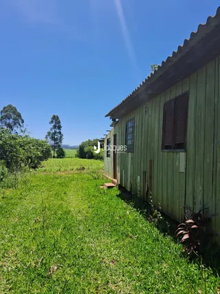 Fachada de uma casa de madeira em Lajeado, Brasil, cercada por grama verde.