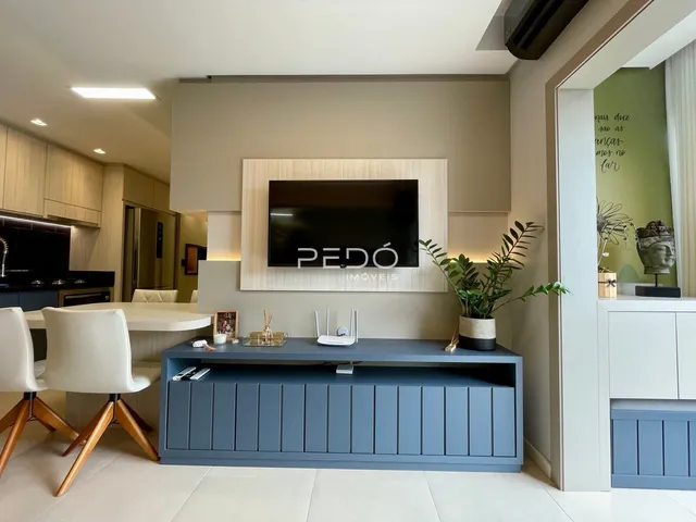 Ambiente moderno de sala de estar com cozinha integrada em Lajeado.