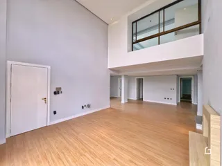 Ambiente interno de uma sala com piso de madeira clara.