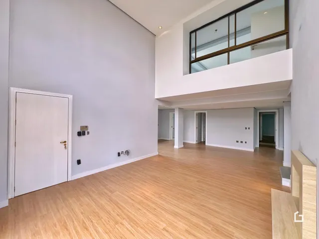 Ambiente interno de uma sala com piso de madeira clara.
