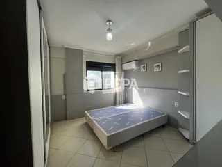Quarto com duas camas de solteiro e paredes cinzas.