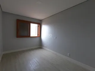 Ambiente interno com paredes cinzas e piso de madeira claro.