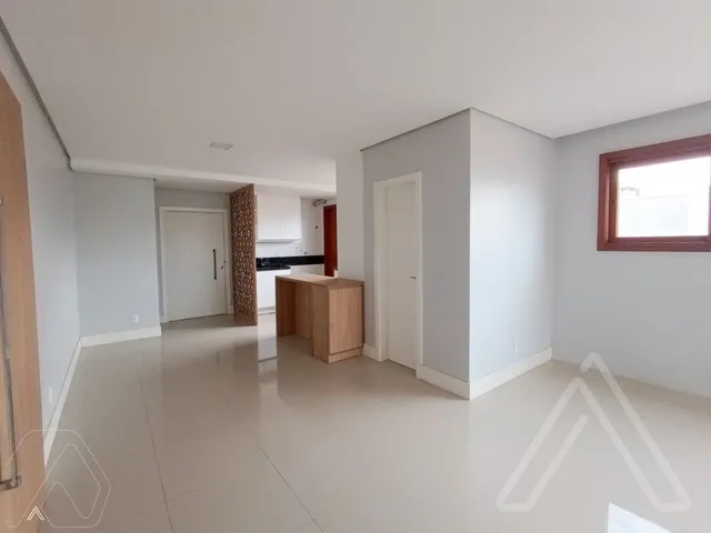 Ambiente interno com piso claro e área de cozinha visível.