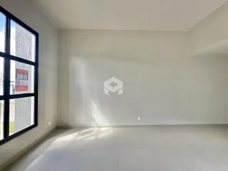 Ambiente interno com grande janela e piso claro.