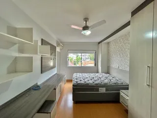 Quarto com cama e armários em ambiente claro.