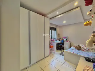 Quarto com armários embutidos e cama decorada em um imóvel no Brasil.