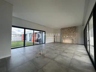 Uma sala de estar ampla com portas de vidro voltadas para o exterior.