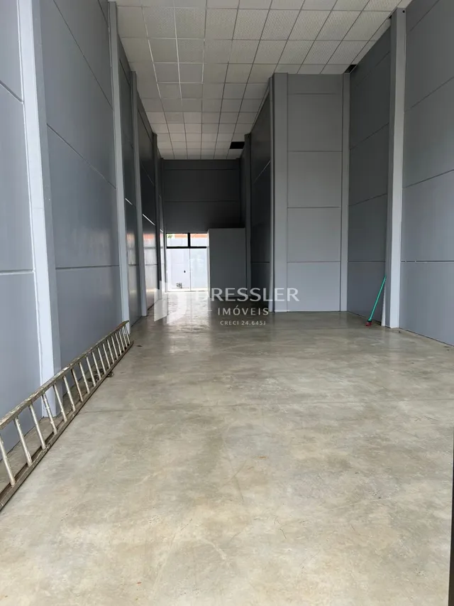 Corredor interno de uma residência com piso de concreto.