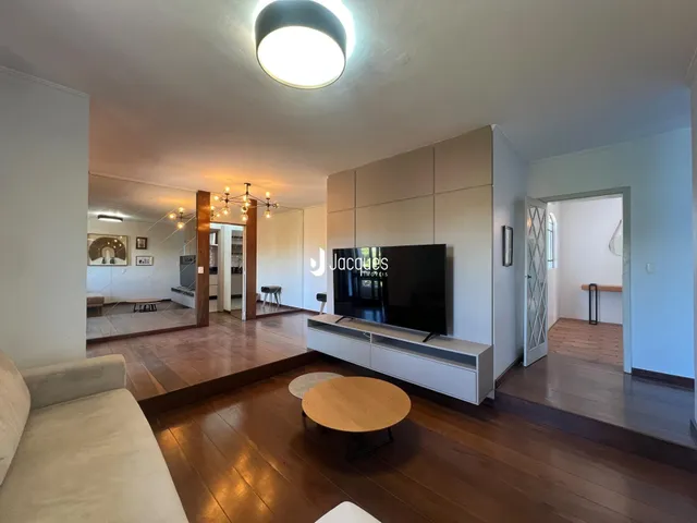 Sala de estar com piso de madeira e sofá claro.