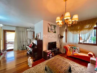 Sala de estar com piso de madeira e cortinas claras.
