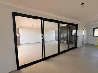 Vista interna de um ambiente com piso claro e paredes brancas.