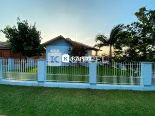 Fachada de uma residência em Lajeado, Brasil, com cerca branca e gramado verde.