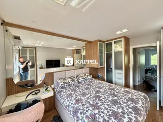 Foto de um quarto com cama grande e painéis de madeira na sala.