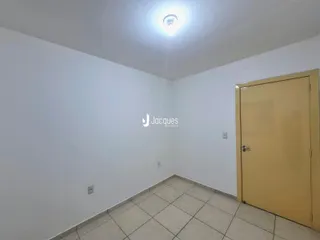Vista interna de um ambiente com paredes brancas e piso de cerâmica.