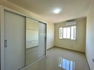 Interior de um ambiente com piso de cerâmica e paredes brancas.