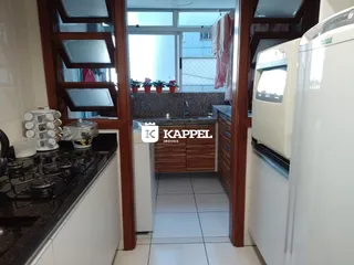 Foto de uma cozinha com bancadas escuras e armários brancos em um imóvel.