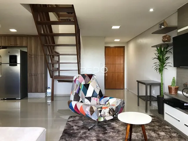 Ambiente interno de uma sala com escadaria de madeira e móveis modernos.