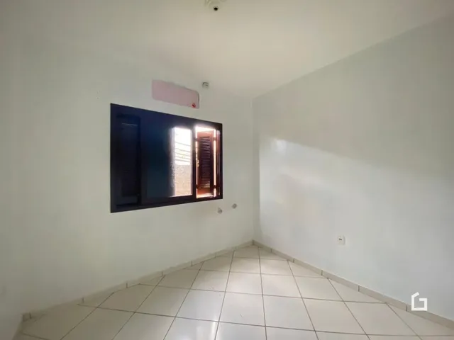 Interior de uma sala com piso de cerâmica e paredes brancas.