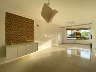 Sala de estar com piso claro e parede decorada.