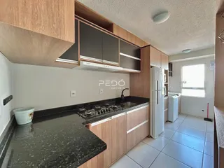 Foto de uma cozinha com armários de madeira e bancadas escuras.