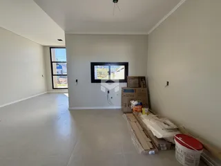 A sala de estar é um ambiente amplo com piso de cerâmica claro.
