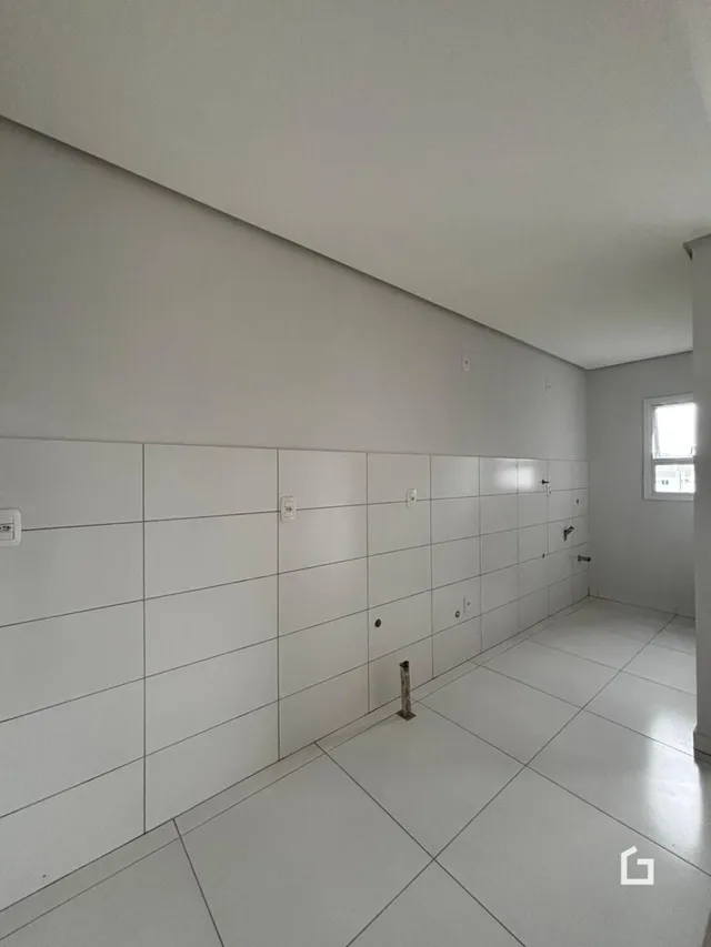 Interior com paredes brancas e piso claro de um imóvel.
