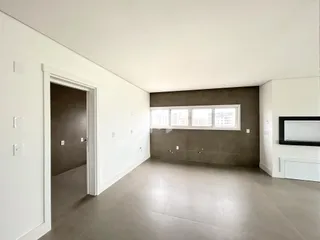Interior de uma sala com piso claro e paredes brancas.