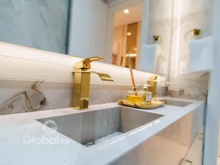 Banheiro com bancada dupla e metais dourados em um imóvel no Brasil.