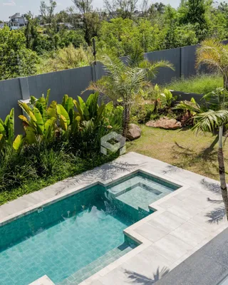 Vista da piscina e jardim tropical de uma propriedade em Lajeado.