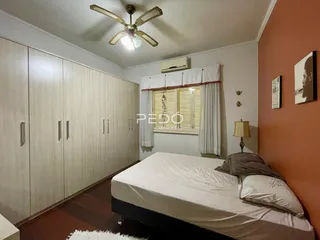 Quarto com armários embutidos e parede laranja.