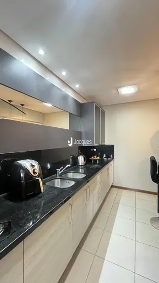 Cozinha moderna com armários escuros e bancadas escuras.