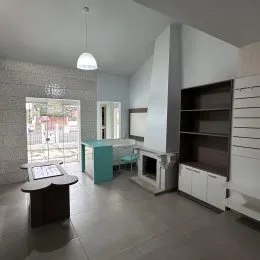 Foto interna de um cômodo com piso claro e estante na parede.