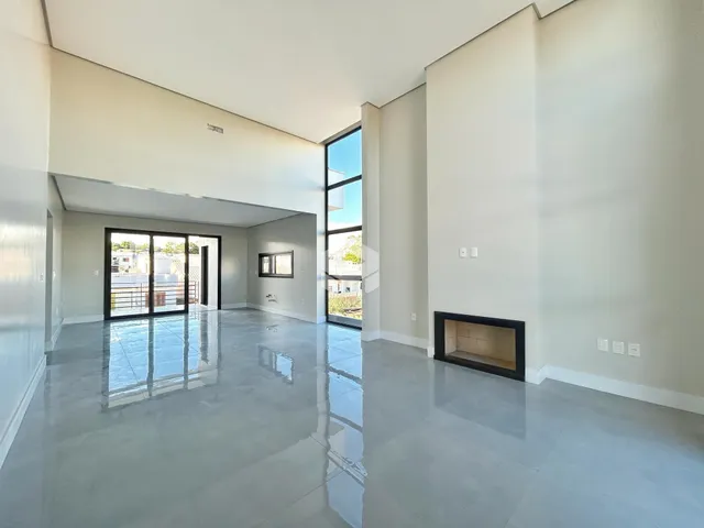 Ambiente interno amplo com piso polido e grandes janelas de vidro.