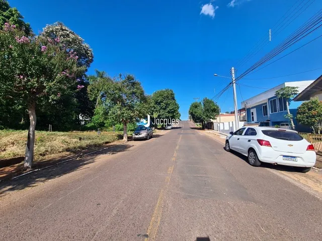 Vista de uma rua com árvores e um carro estacionado em Lajeado, Brasil.