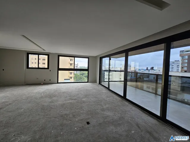 Ambiente interno de uma sala com piso de concreto e grandes janelas.