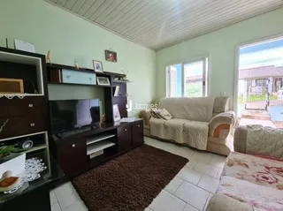 Sala de estar com sofá e televisão em ambiente claro.