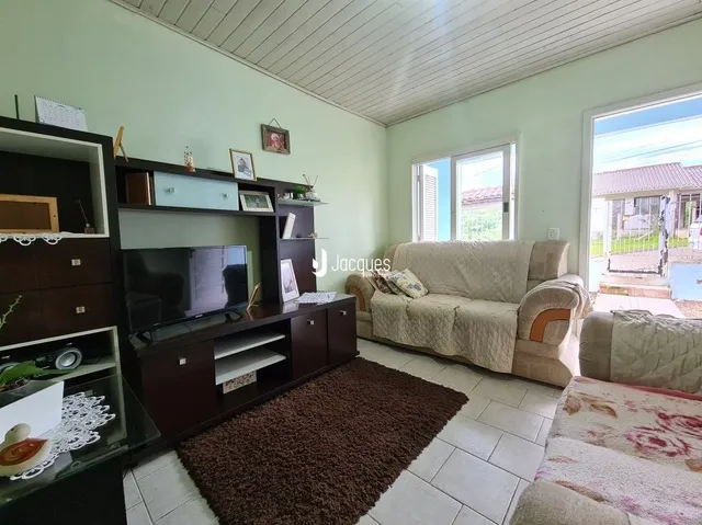 Sala de estar com sofá e televisão em ambiente claro.