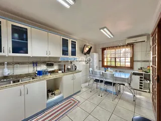 Cozinha com armários brancos e piso de cerâmica.