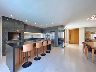 Vista da cozinha moderna com ilha e bancada escura em Lajeado.