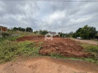 Paisagem de terra e vegetação com uma pilha de terra no meio.