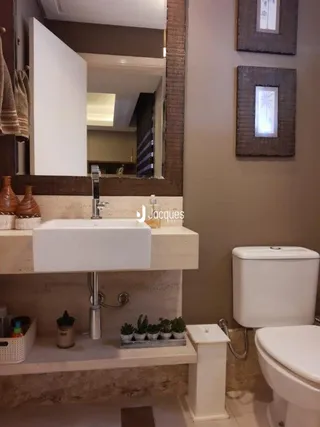 Detalhe da bancada e vaso sanitário de um banheiro.