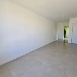 Hall de corredor interno com paredes brancas e piso claro.