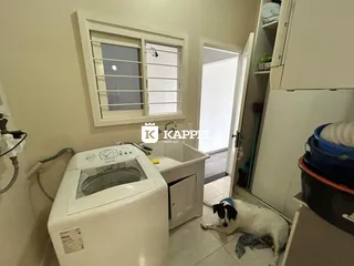 Foto de uma área de serviço com máquina de lavar e pia.