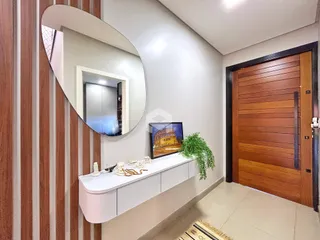 Corredor com porta de madeira e espelho decorativo.