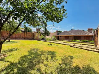 Vista externa de uma propriedade com gramado e muro de tijolos em Lajeado.