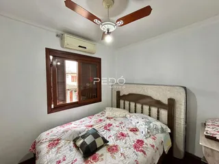 Quarto com cama de madeira e janela no interior de uma residência.